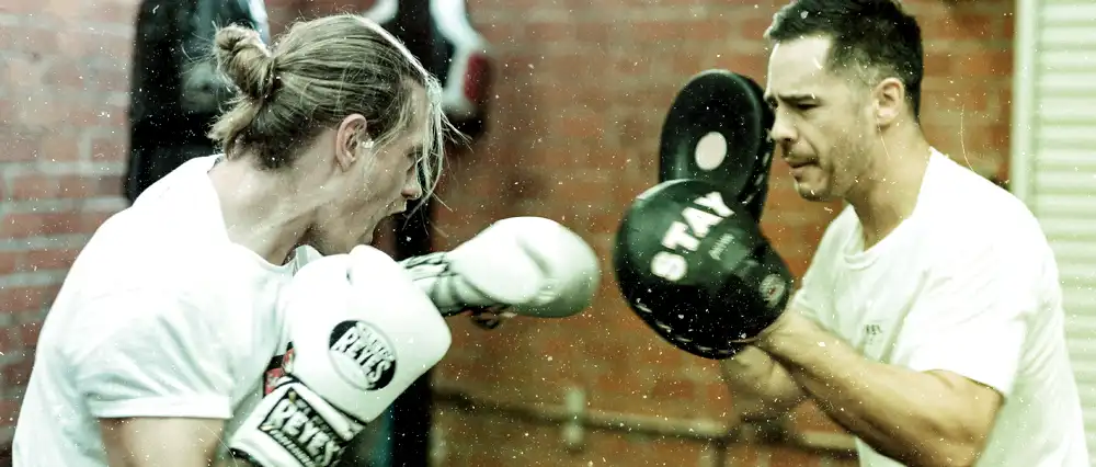 Two men sparring in a martial arts gym.