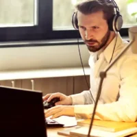 How to Be More Productive: 12 Ways to Better Manage Your Time Man working at the desk with Laptop.