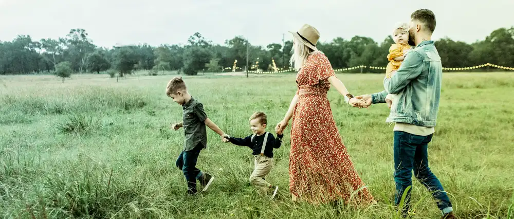 Family walking through a countryside field.