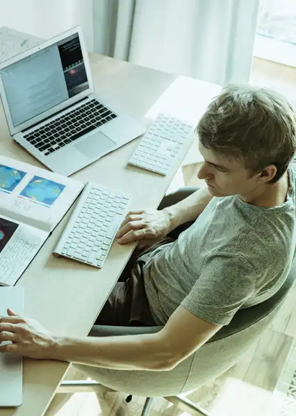 Man at desk with Laptop working hard.