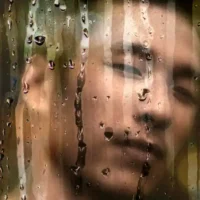 Why Do You Want People to Feel Bad for You? All You Need to Know Man looking through rain water dripping glass.